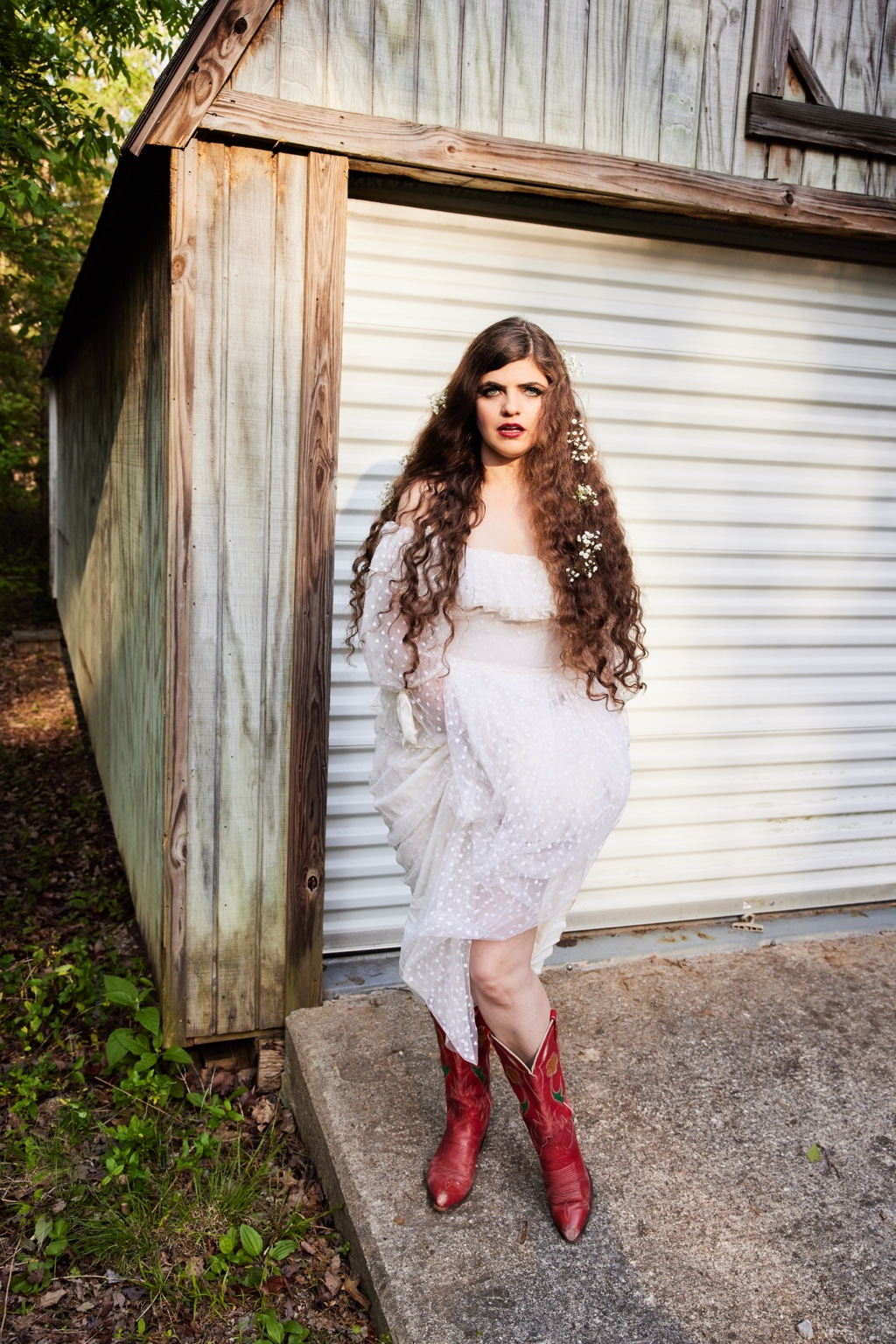 Nettie in a white dress and red boots